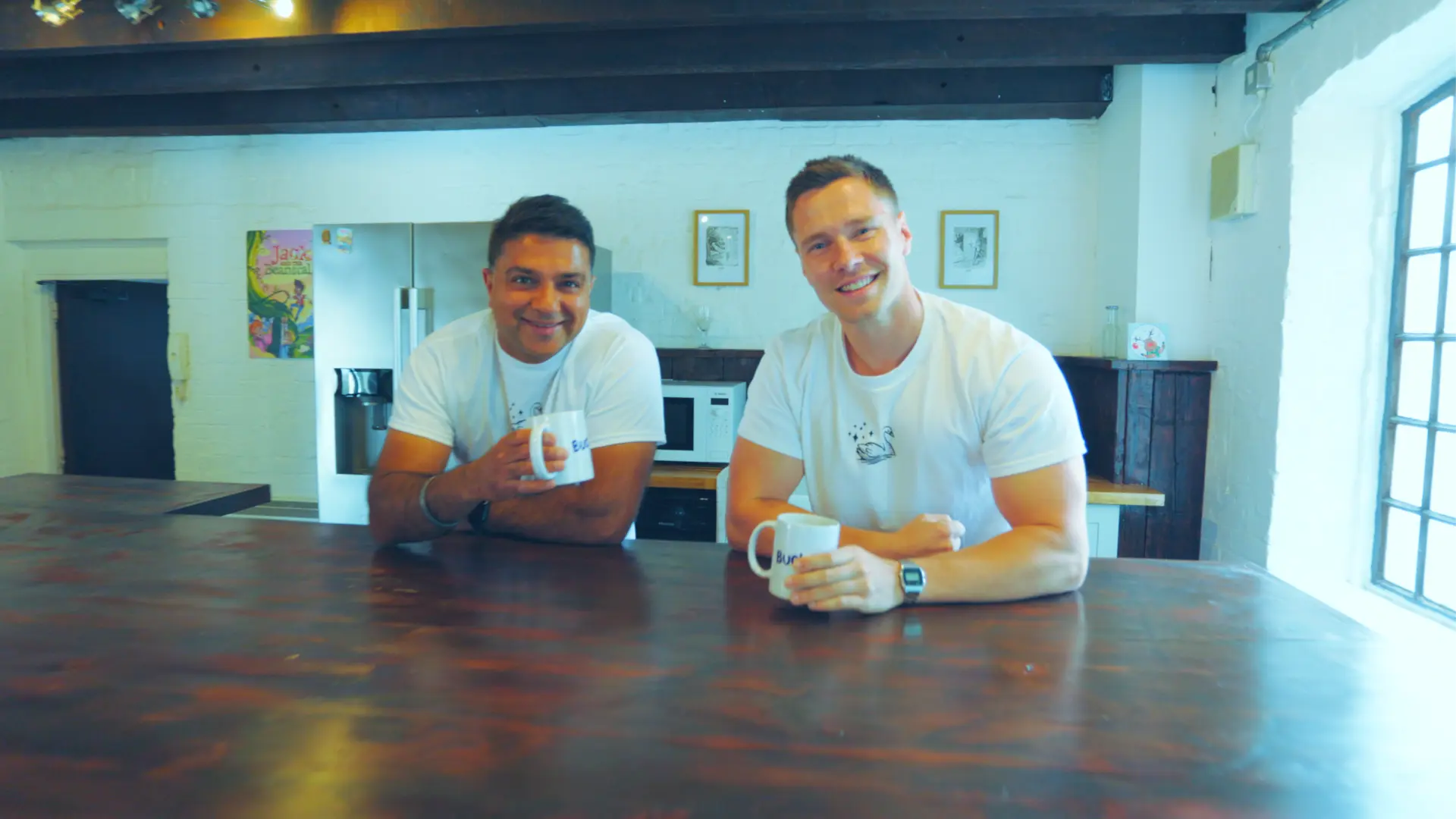 The directors of Spirit Bridge Studio (SBS), Pritpal Rai (left) and Ben Barter (right), drinking coffee from personalised SBS mugs.