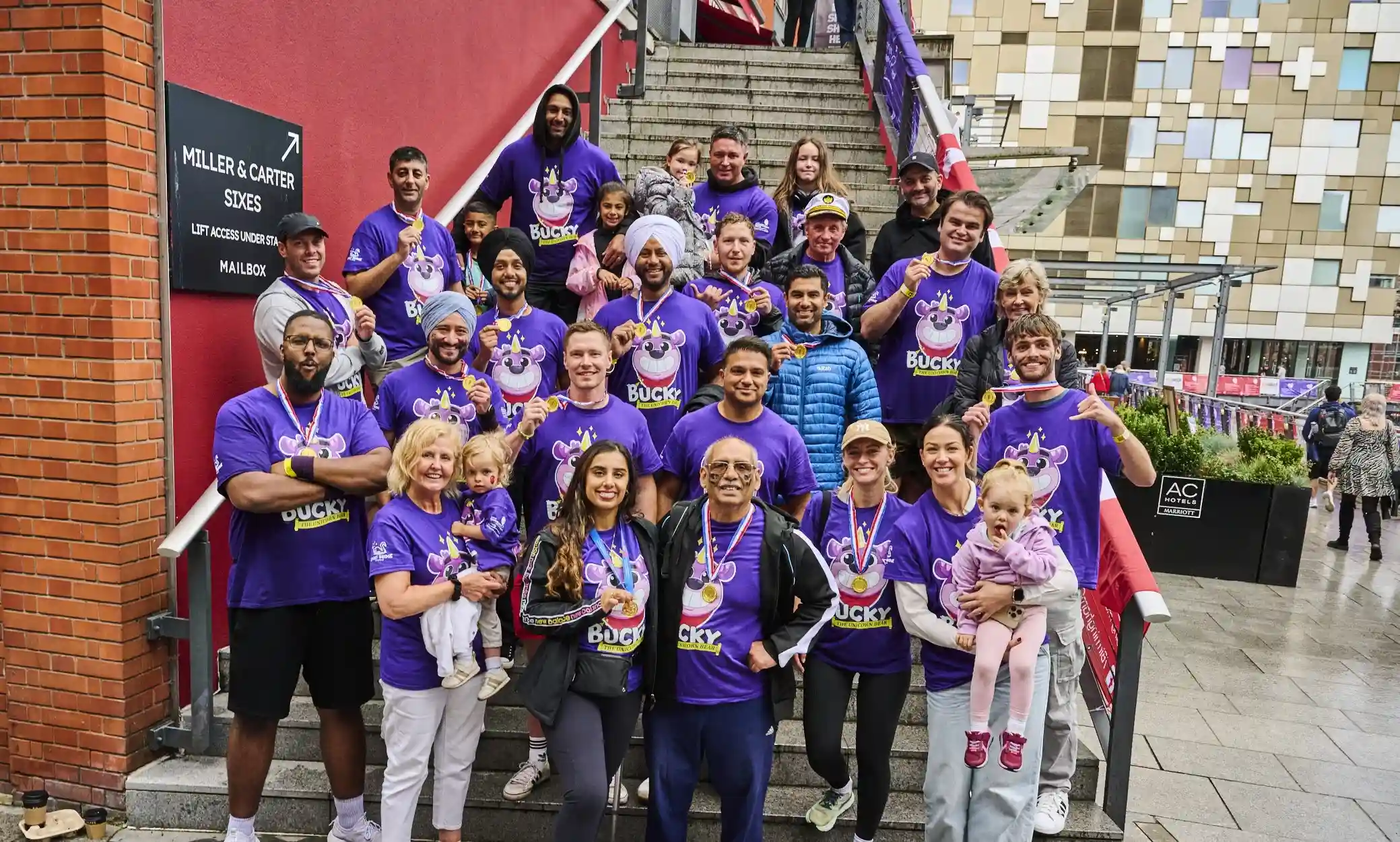 Team Bucky showin their gold medals, after raising the biggest amount of money ever by a team, at the Dragon Boat Race, in Birmingham (@ The MailBox) 2025.